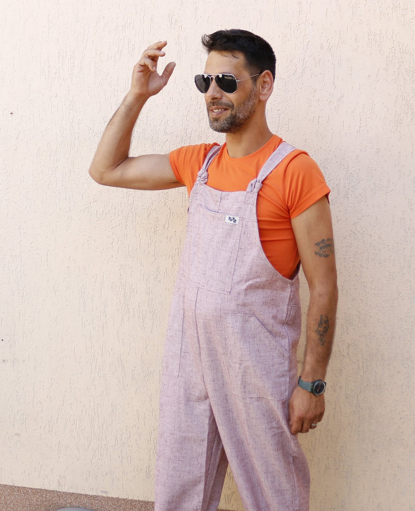 man wearing YAYS linen dungarees in Pink Sand, posing front left-side