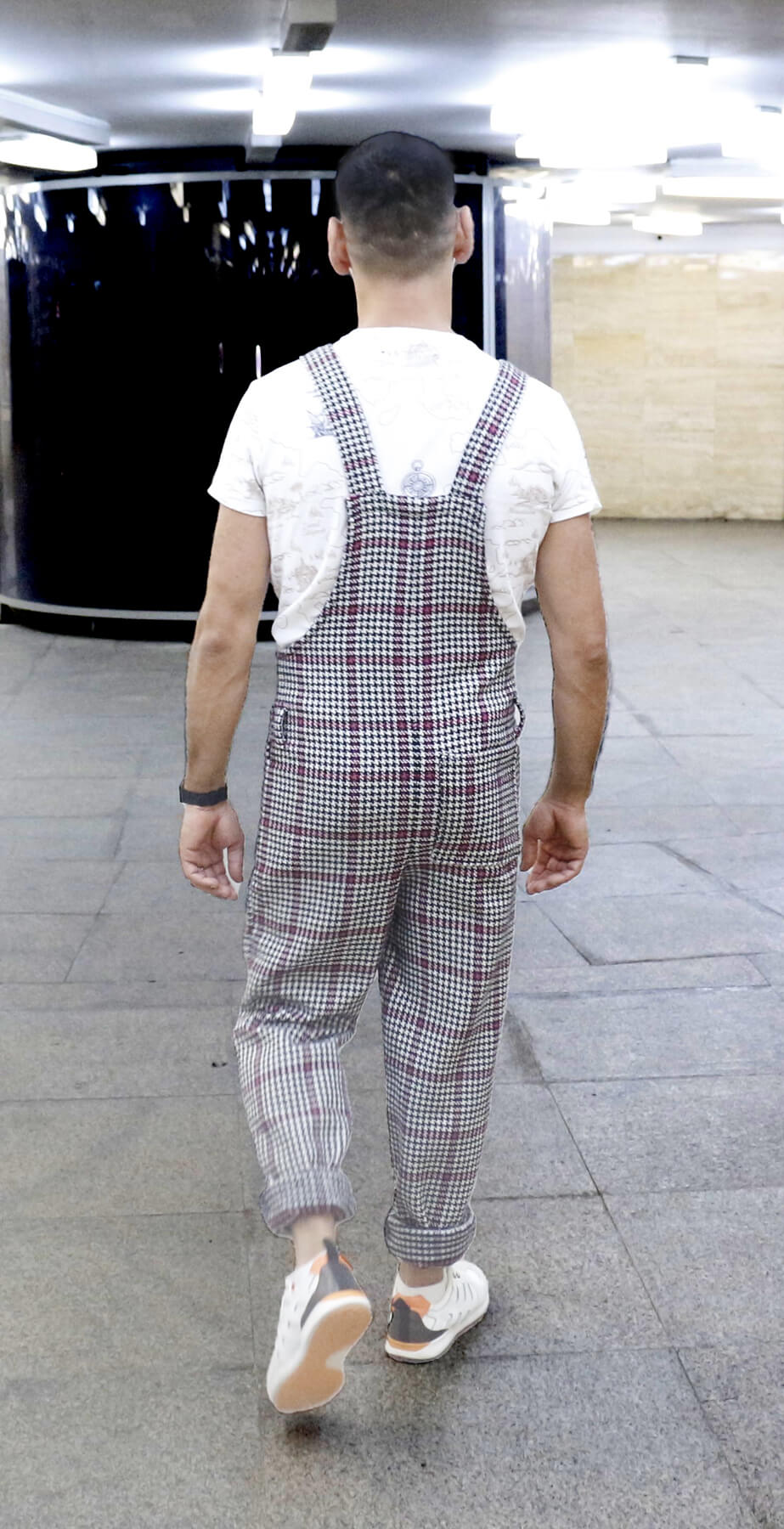 man wearing YAYS cotton wool overalls, posing while walking, back view